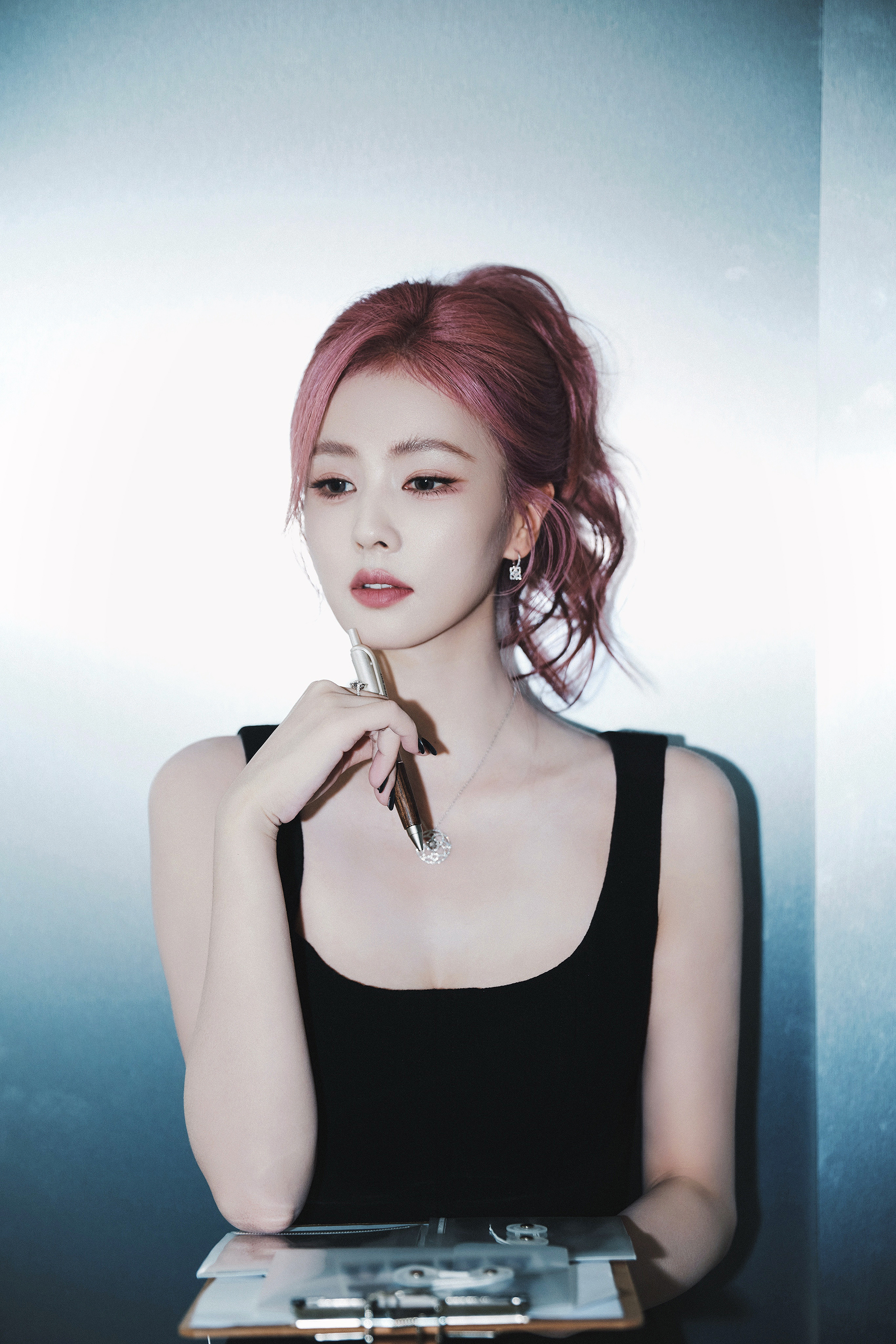 白鹿一身黑裙勾勒出随性与精致的边界，粉发似揉碎的晚霞，在纯白空间里晕染出独属于