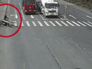 路口斑马线上，大爷骑着三轮车横穿道路，车上违规装载超长管材。行驶时向外延伸的管材