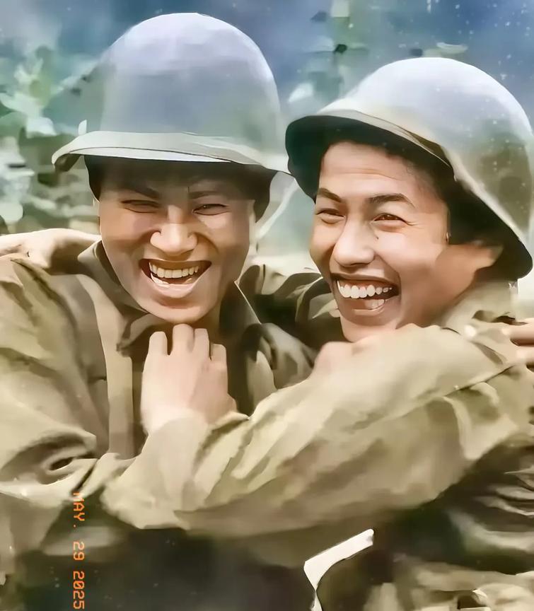 1985年，刚刚从老山战场上走下来的兄弟俩。他们头戴钢盔，身上的军装在炮火硝烟中