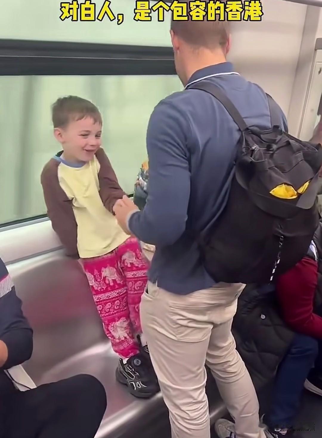 这对外国父子在香港地铁上，可以说是相当的松弛，小男孩站在座位上玩的是不亦乐乎，貌