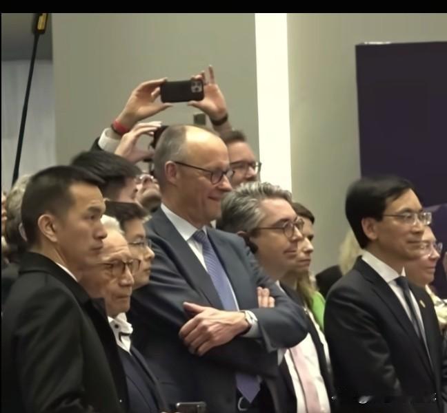 王兴兴又迎来人生高光时刻。一身正装站在德国总理默茨身边，不卑不亢的肃穆神情充满