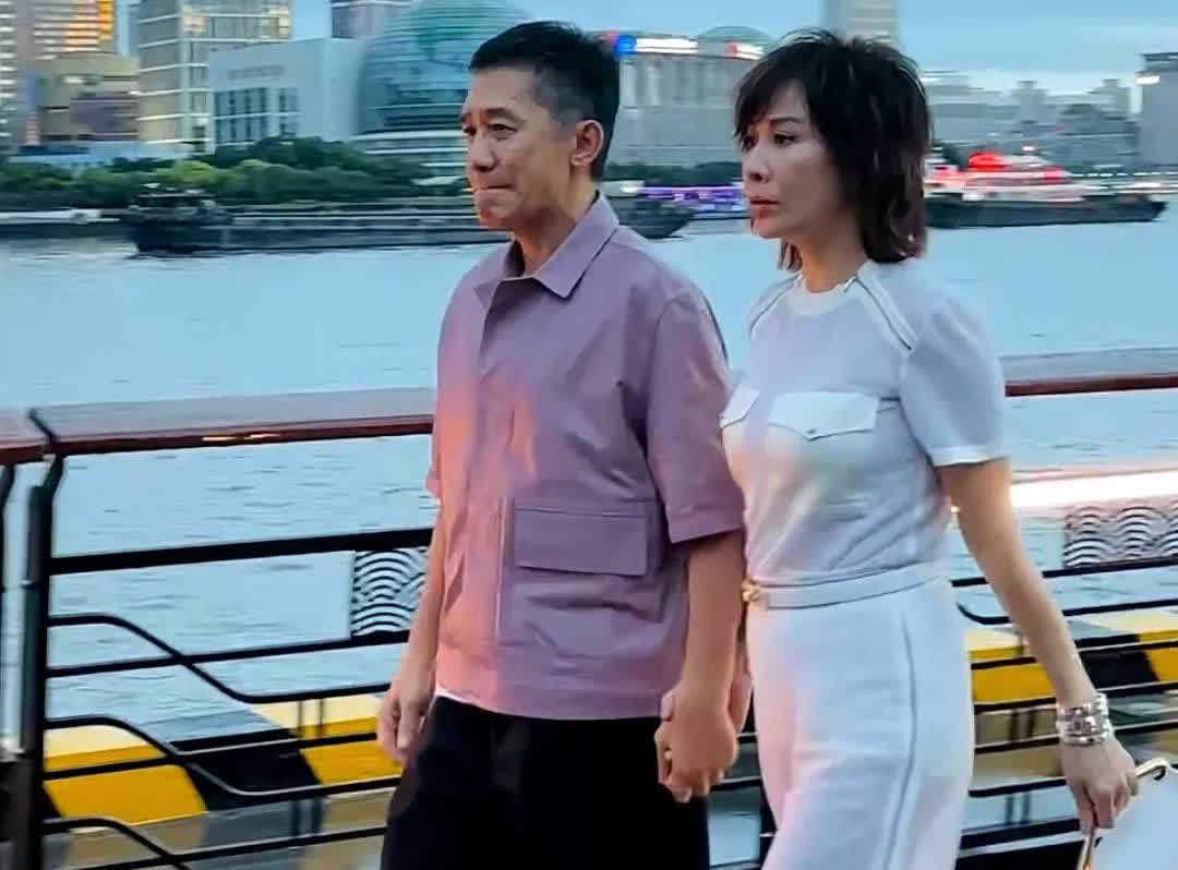 刘嘉玲拉着社恐老公出席活动，谁注意62岁梁朝伟的样子？耷拉着眼睛，抿着嘴，好像一