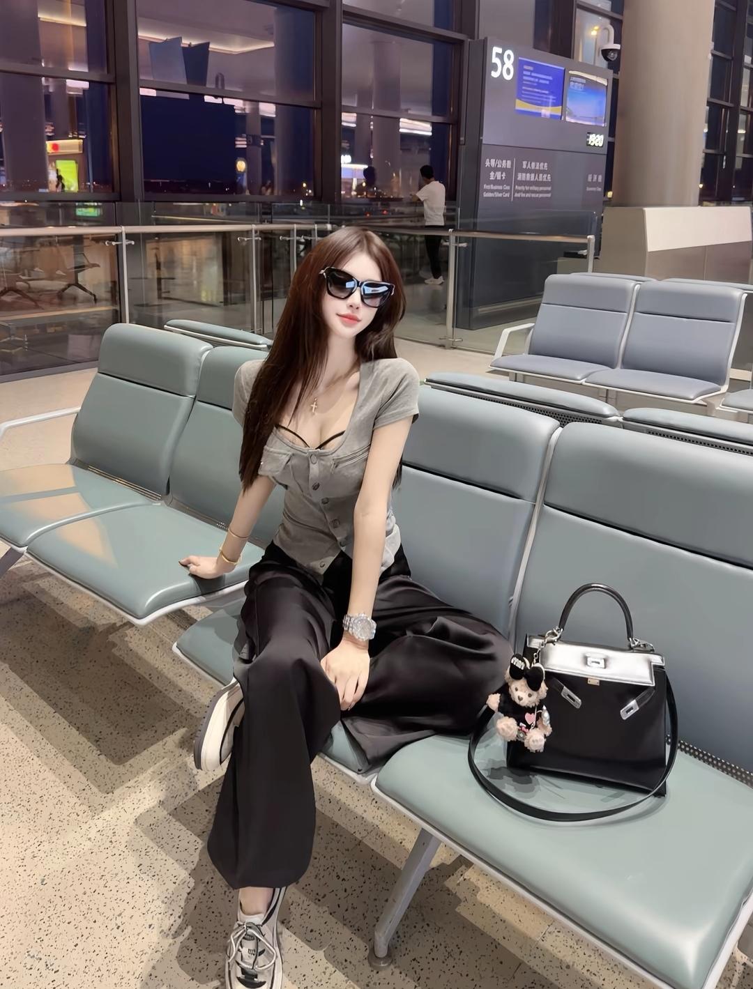 机场候机室的时尚少女，黑白色调穿搭，手提包和毛绒玩具相伴，轻松自在。