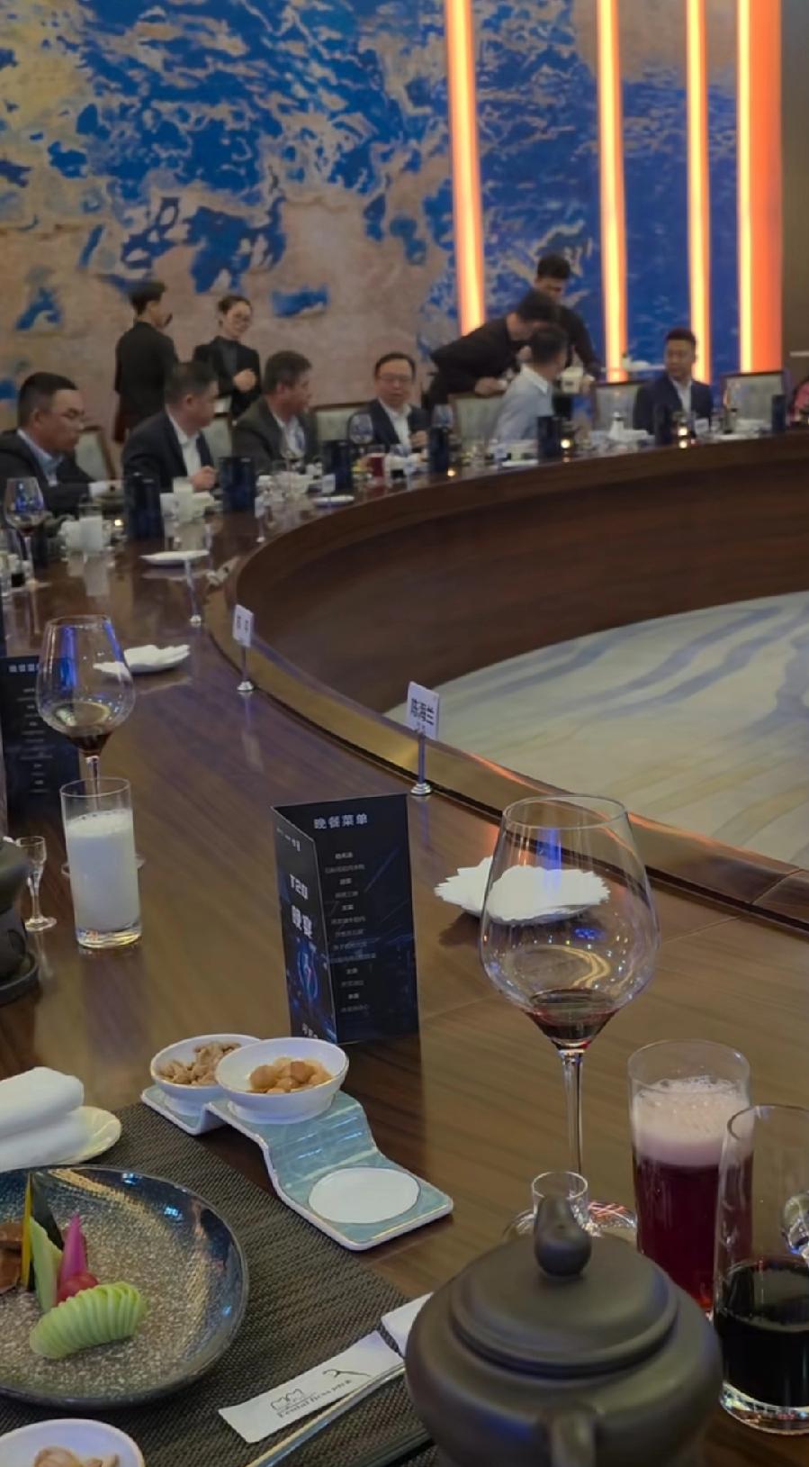 比亚迪经销商晚宴，深圳总部食堂自助餐房间，超大圆桌，中间装饰景色亮了，一片一堆绿