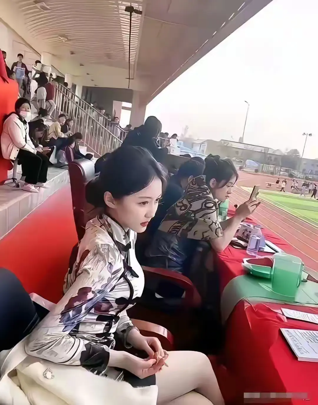 这位美女是什么身份呢？她凭什么能坐在主席台上？