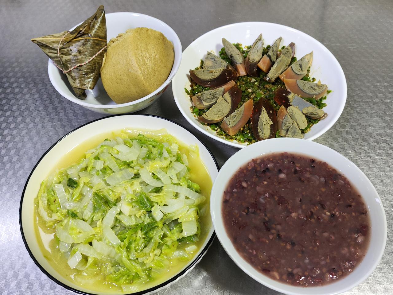 6月25日的晚餐，有红豆粽子、半个荞麦馒头，搭配青椒皮蛋和清炒白菜，还有一碗五谷