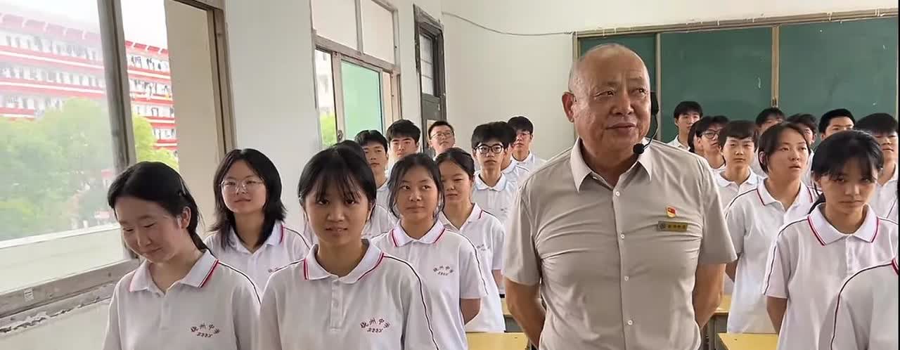 饶州中学王国喜手里拿着烟，从校内快步走出来敲打了一下女同学的手臂，感觉这位女同学