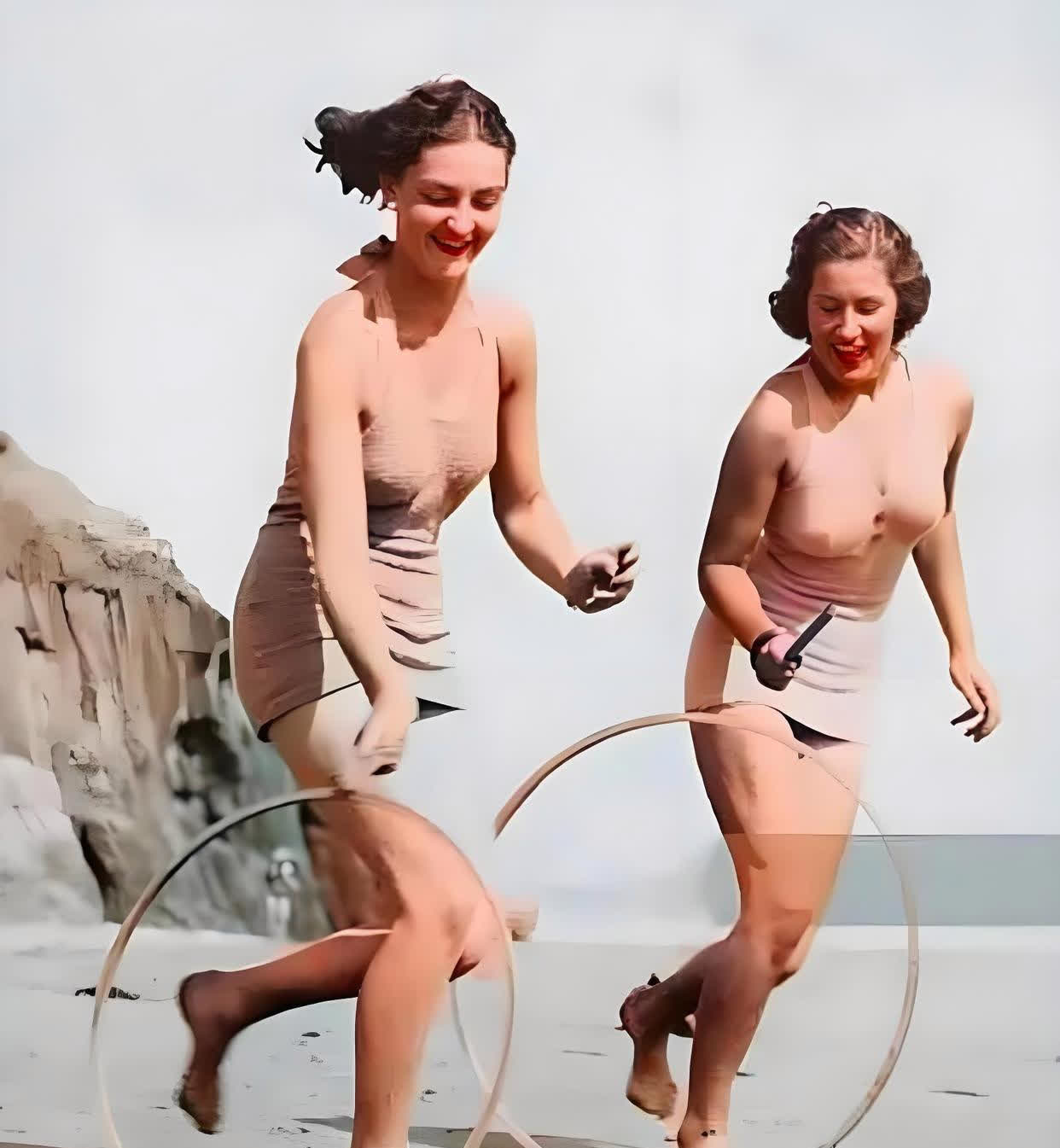 大约在1930年，英国的某个海滩上，两位短发的性感美女穿着挂脖泳衣，欢快地奔跑着