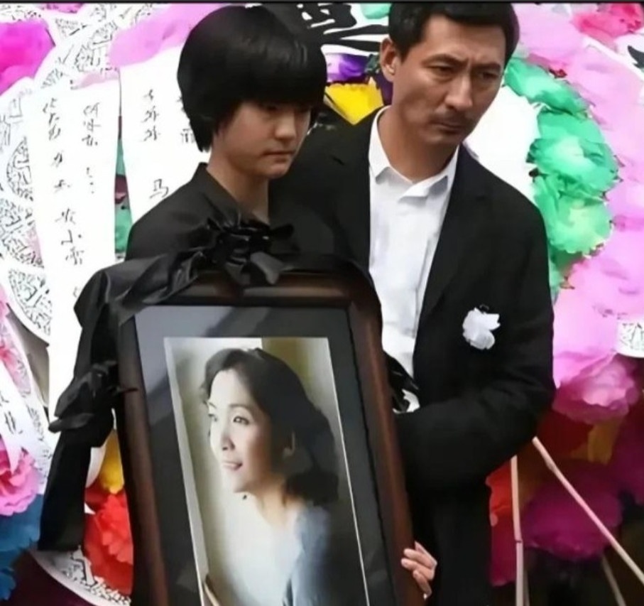 2012年，演员李婷的葬礼上女儿抱着她的遗像，一旁是她的前夫张子健，她病危的时候