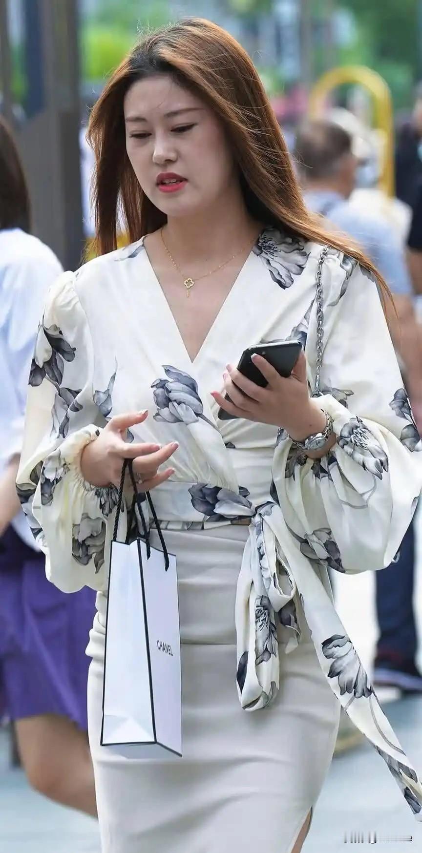 穿花衬衫裙的女士在走路。