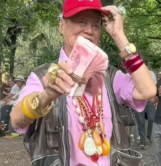 在成都某公园里，常能见到一位大爷手持现金四处走动，颈脖子挂满了玉器，双手带着金表