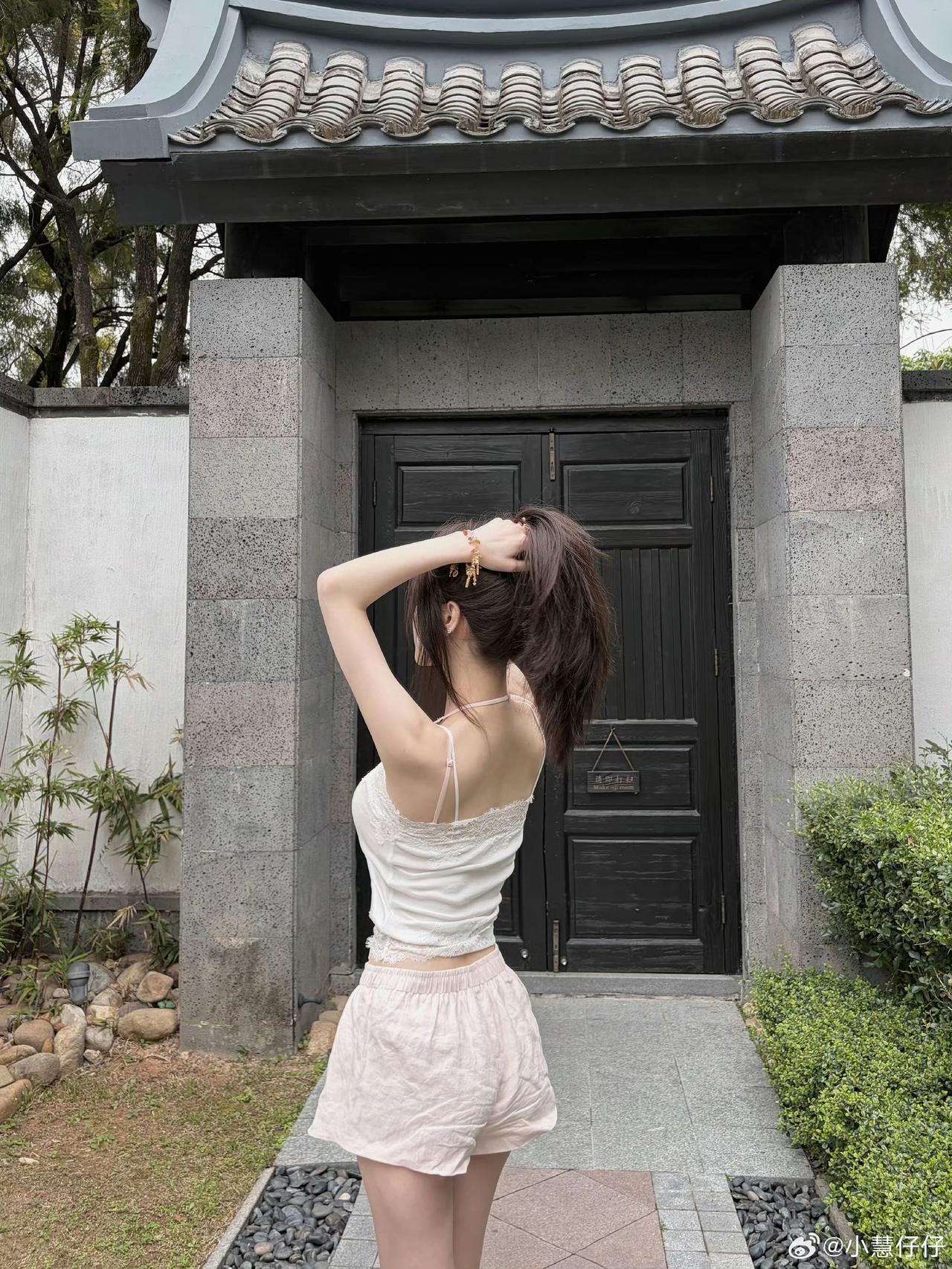 夏日穿搭指南：清新白色背心+粉色短裤，搭配传统中式建筑，轻松自在。