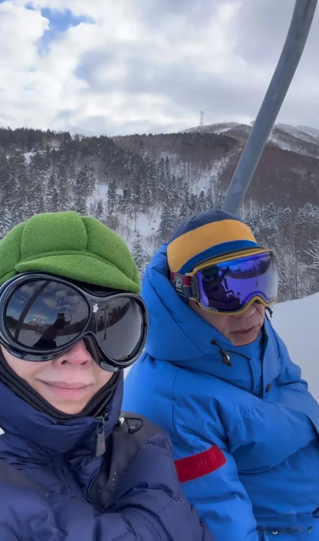 刘嘉玲和老公梁朝伟现身北海道滑雪，嘉玲姐戴着一顶绿色帽子，穿着一件墨蓝色羽绒服，