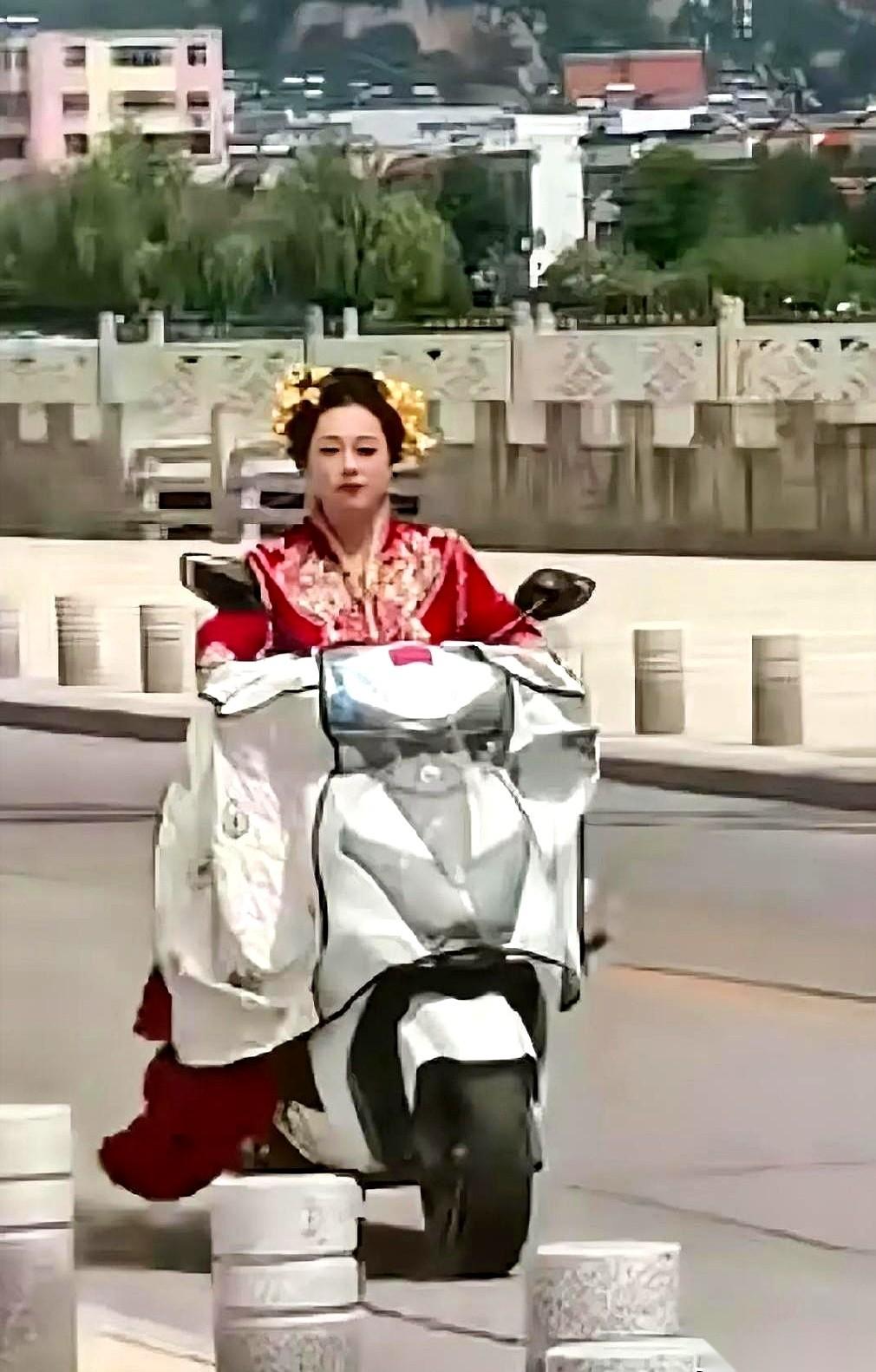 河南周口赵庄村的土路上，一个穿着大红秀禾服的姑娘，“啪”地一声扣上塑料头盔，把陪