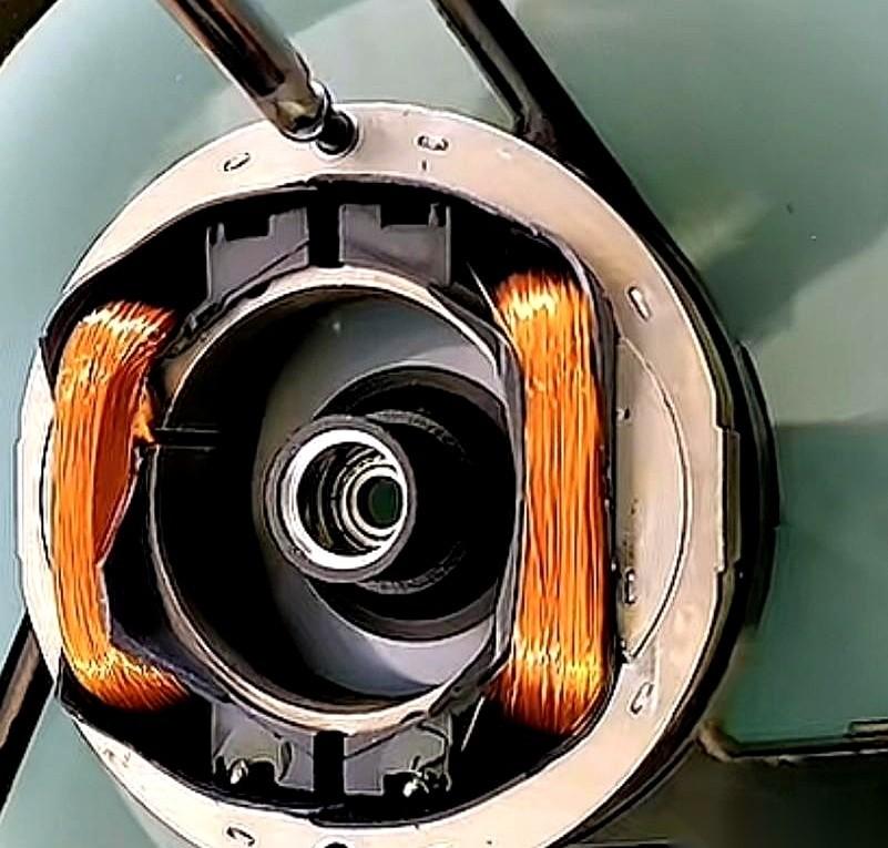 桌上摊着个拆开的220伏小电机，零件铺了一报纸，一个老伙计翻来覆去地找，眉头拧成