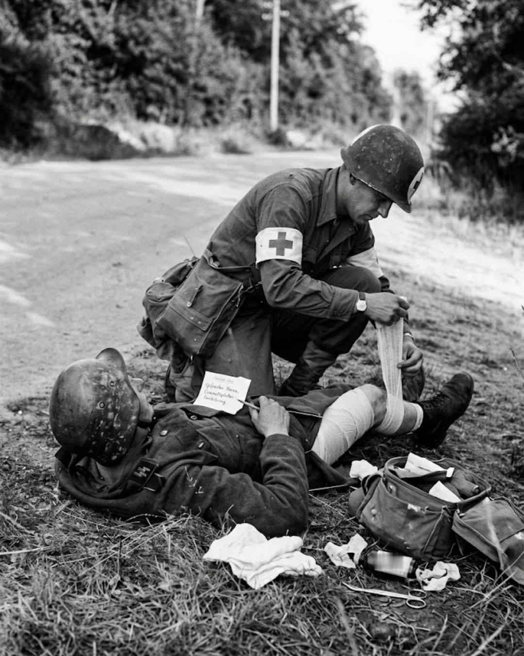 1944年，美军医护兵正在给一名德军伤兵包扎伤口！该德军士兵无亚于中了头彩，