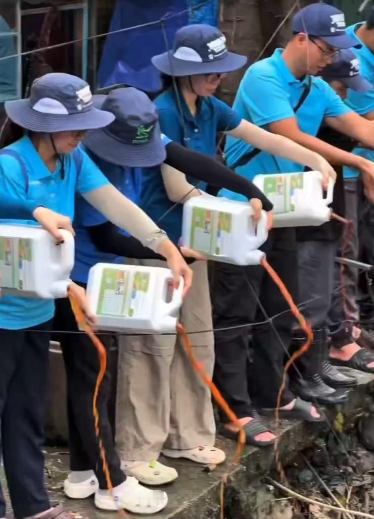 西贡青（SaiGonXanh）等组织的越南青年正在将有效微生物（EM）倒入胡