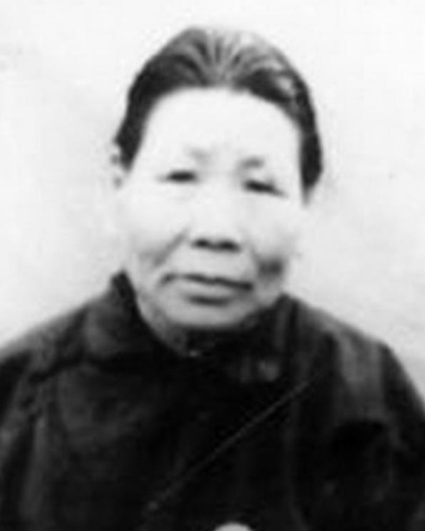 1941年11月，明德英坐在草屋前逗不满周岁的孩子玩，由于她是聋哑人，听不到声音