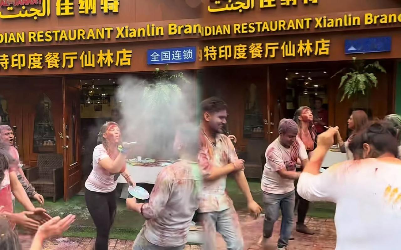 南京仙林，印度餐厅自发组织庆祝酒红节，老板和顾客都在路边喷洒彩色颜料，把地面弄得
