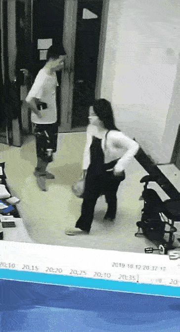 监控下，一位背包年轻女人，驻足在前台，一年轻男子，围着她打圈转，趁女子没注意，年