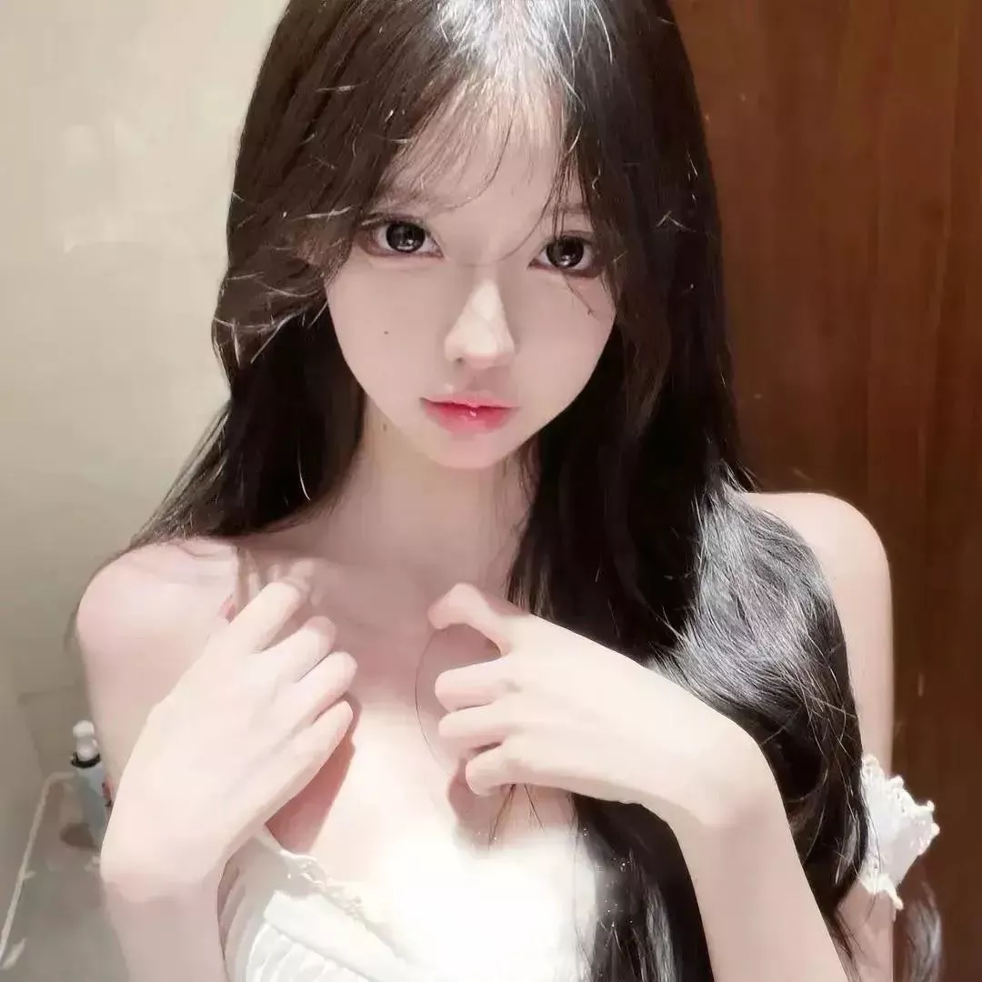 甜美可爱的少女，轻轻抚摸胸口，展现出迷人的魅力。