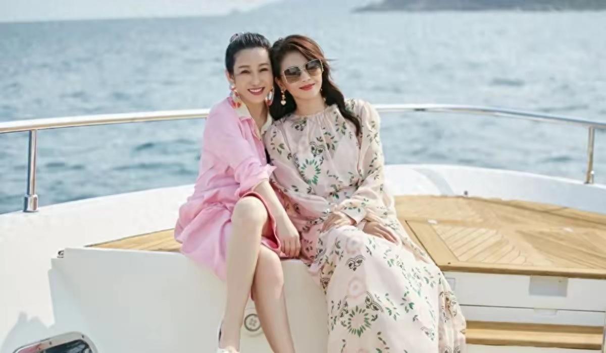坐在游艇船舷的秦海璐，靠着一身浅粉色oversize衬衫裙成了视觉焦点，宽松的衬