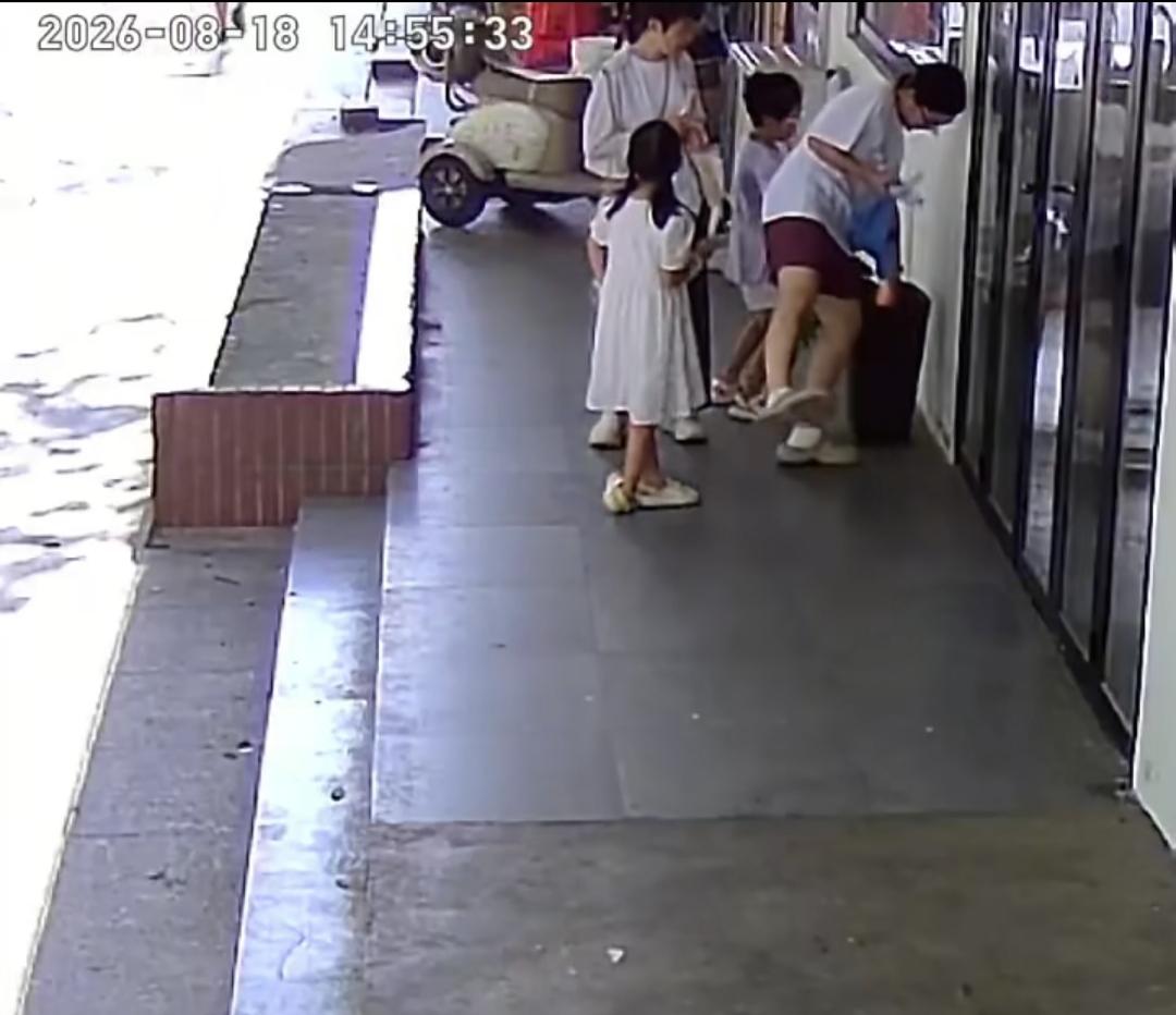 8月18日，江西景德镇，两名女子带着两个孩子路过一家店铺门口。店门前摆放了一盆养