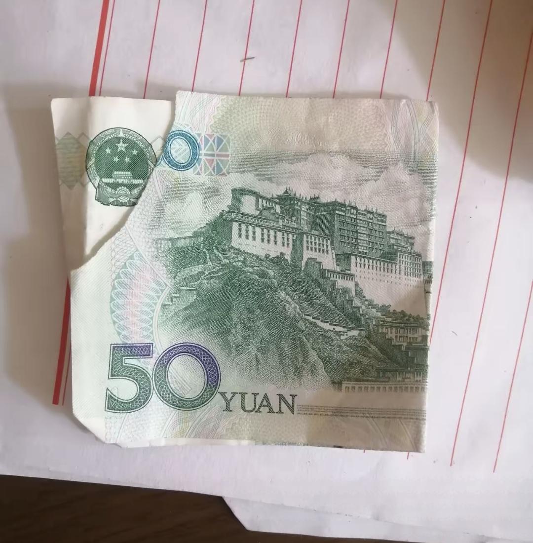 昨天早上在菜市场买了三十块的熟食，给了一百让找零。摊主打来两张纸币，叠着放的五十