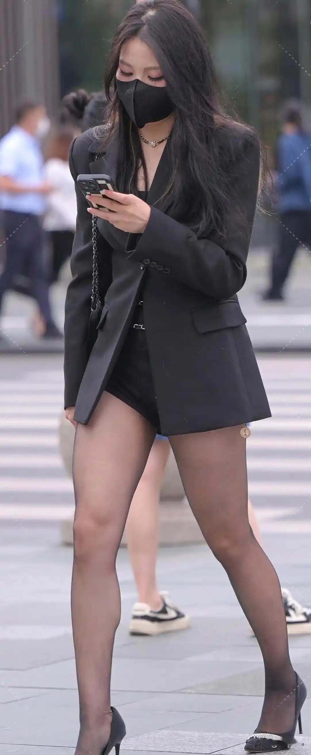 都市时尚女郎，黑色西装外套搭配黑色丝袜，优雅大方。