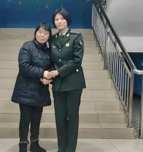 2025年，华坪女高楼梯前，张桂梅校长紧握前来探望的学生丁王英的手，彼时的丁王