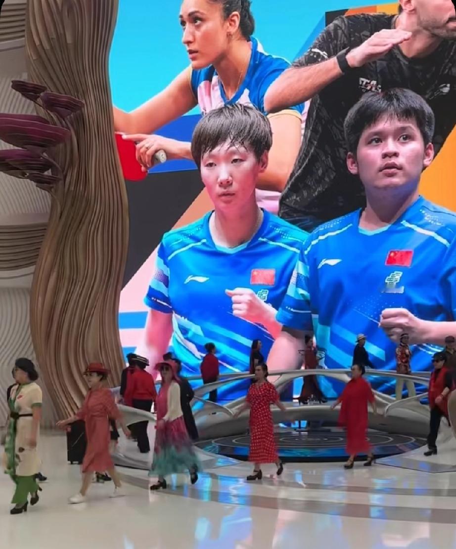 海口商场里的乒乓球亚洲杯巨屏宣传海报，王曼昱林诗栋作为中国队代表登上大屏。王曼