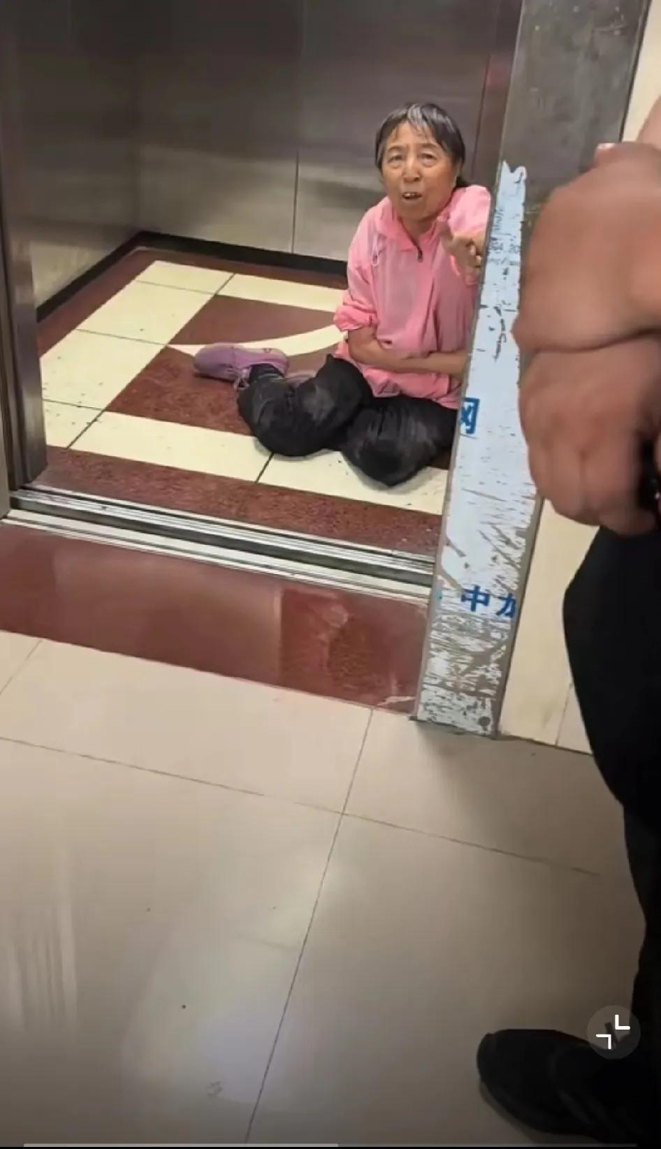内蒙古，一个大娘摔倒在电梯内爬不起来，她向电梯外面的三个男子求救，但没有一个男子