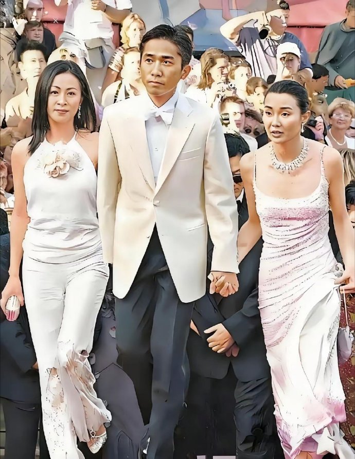 这张照片拍摄的是2000年戛纳电影节红毯上的经典一幕梁朝伟一手牵着女友刘嘉玲，