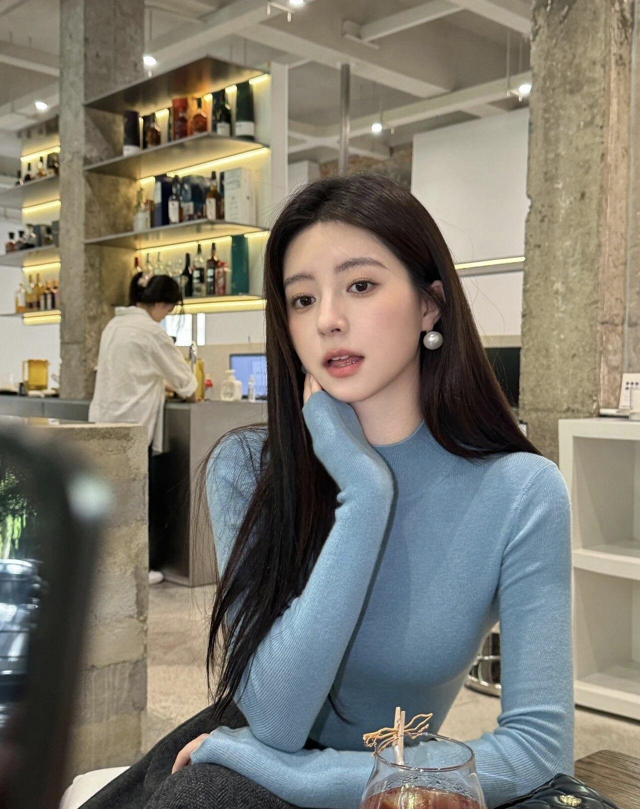 浅蓝针织衫搭配深灰半身裙，在街角与暖阳撞个满怀，慵懒又惬意