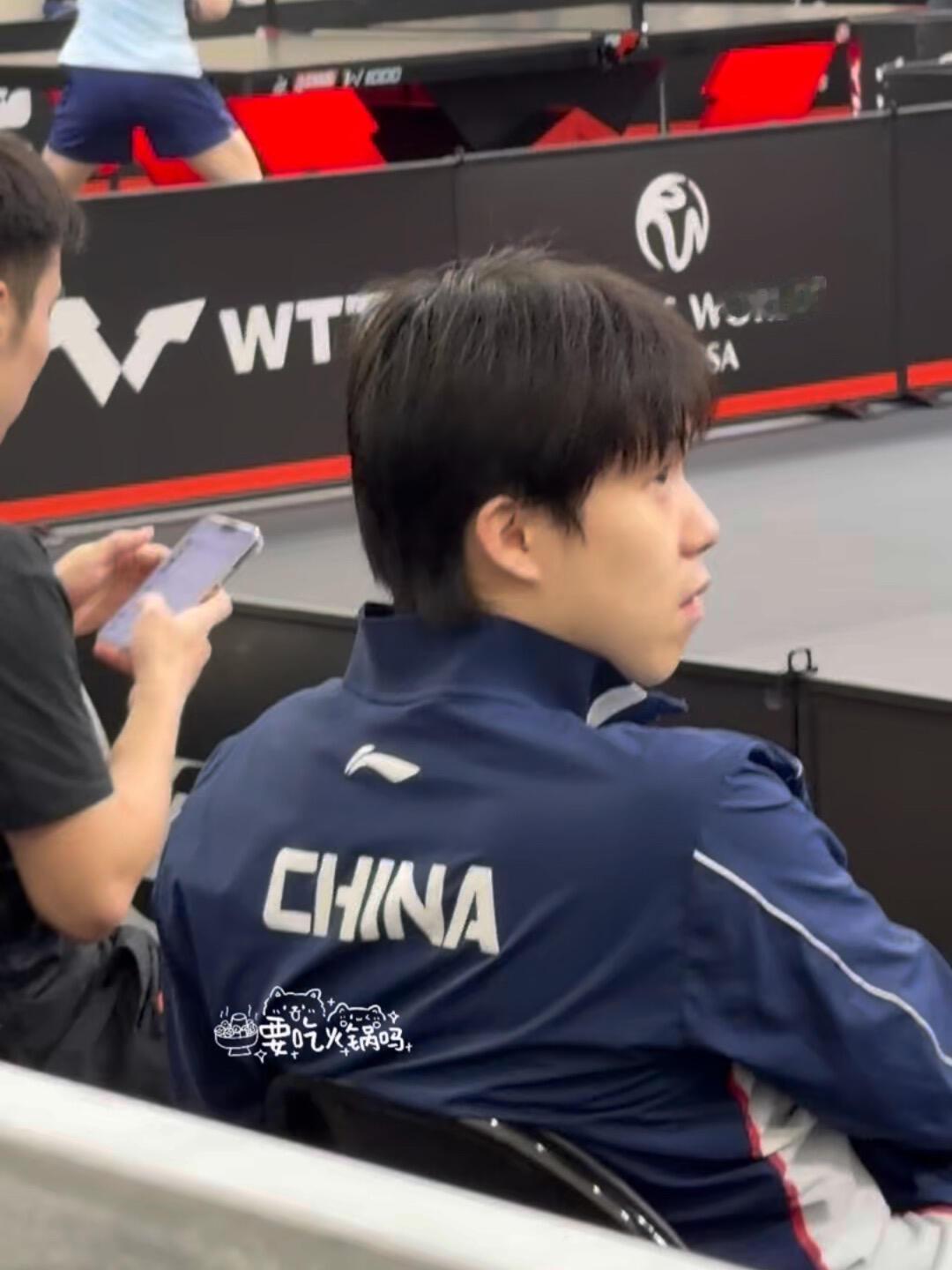 王楚钦在休息，顺便吃个香蕉，头哥好潇洒自如，坐姿很霸气！这个视角离训练场很近了