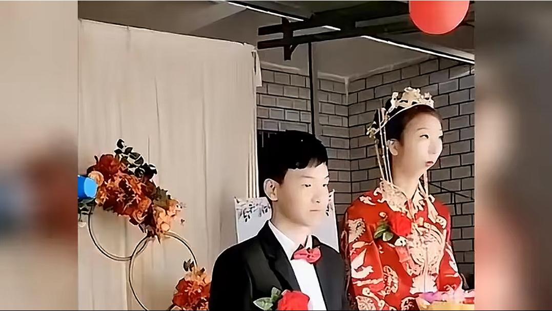 广东一婚礼上，新娘容貌特殊，新郎全程面无表情。新娘没有长下巴，个子还是挺高，身材