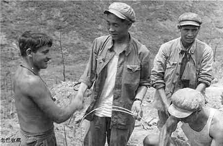 1953年，朝鲜战争结束后，中美士兵放下了手中的枪，相互握手致敬。他们脱下军装，