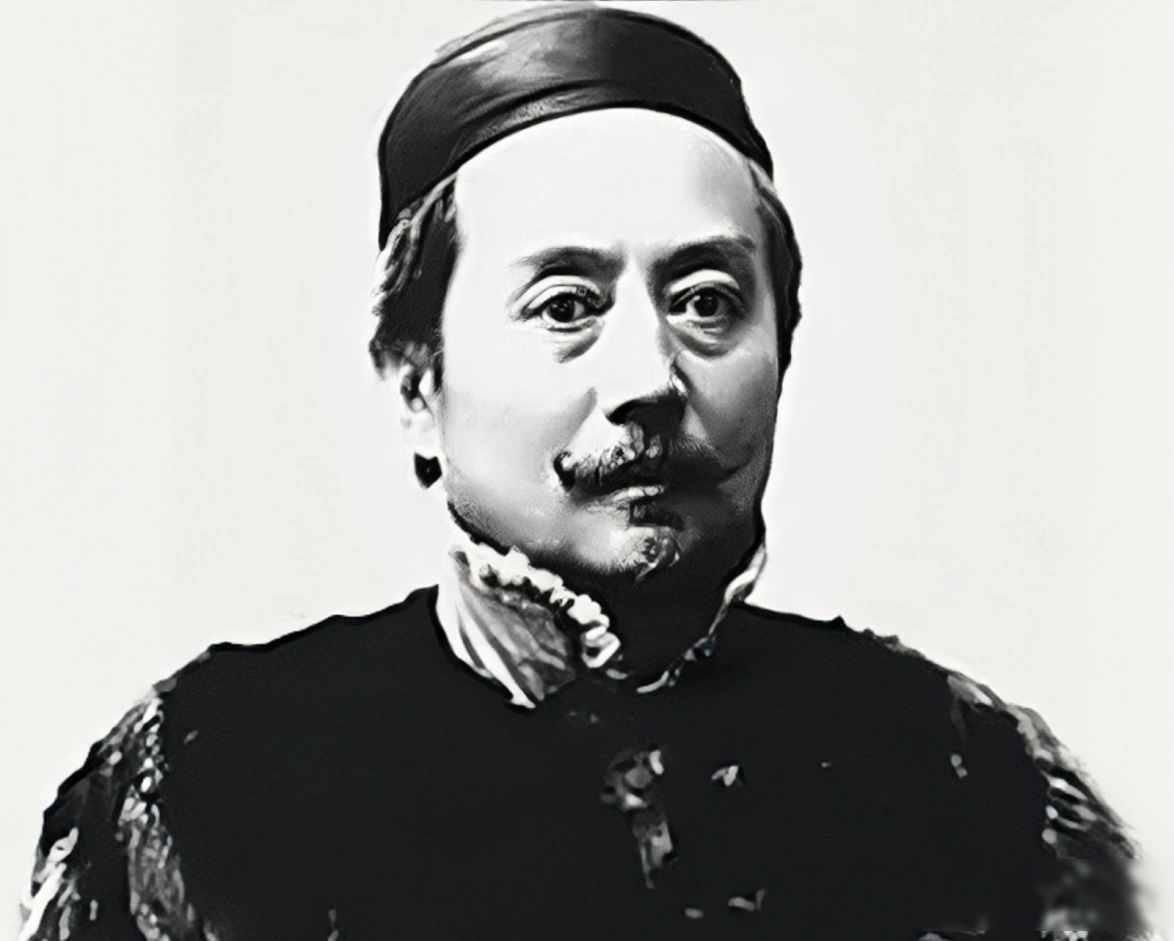 1871年德国火车上，辜鸿铭手拿报纸，倒着在看。两名德国小伙在一旁用德文嘲讽：“