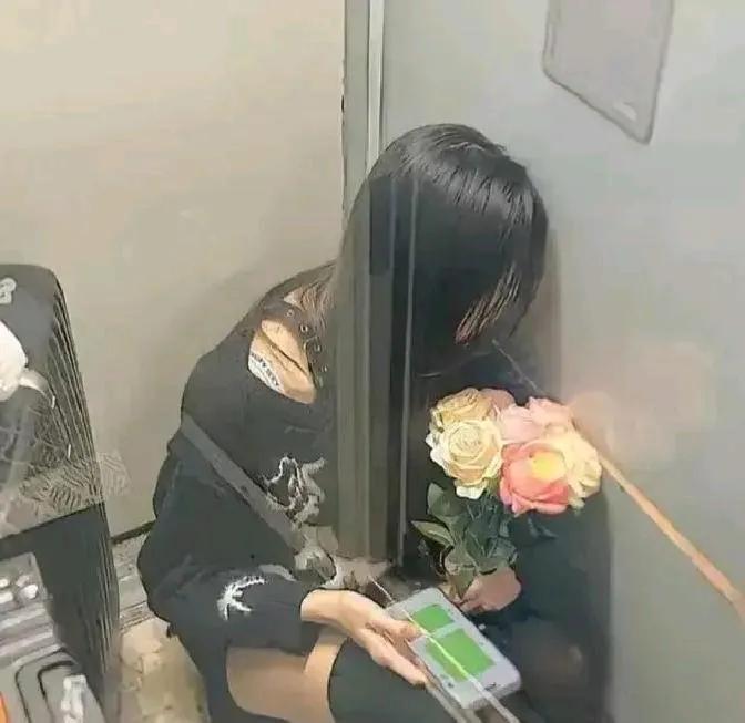 江西的女孩坐在火车的过道里，一手捧着鲜花，一手拿着手机。手机不停地闪烁着，有很