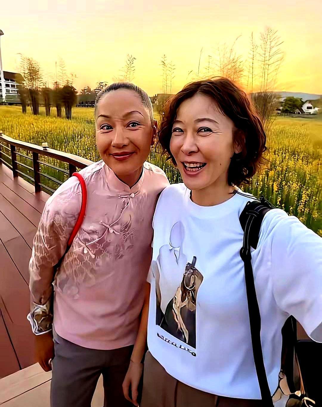 两个53岁的女人，在泰国的油菜花田里合了影。巧的是，二十年前，她们的名字都和同