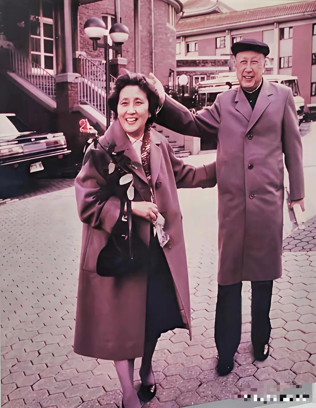 1987年德国街头，钱学森轻抚妻子蒋英发顶满眼宠溺。蒋英笑眼弯弯，手捧玫瑰，这藏