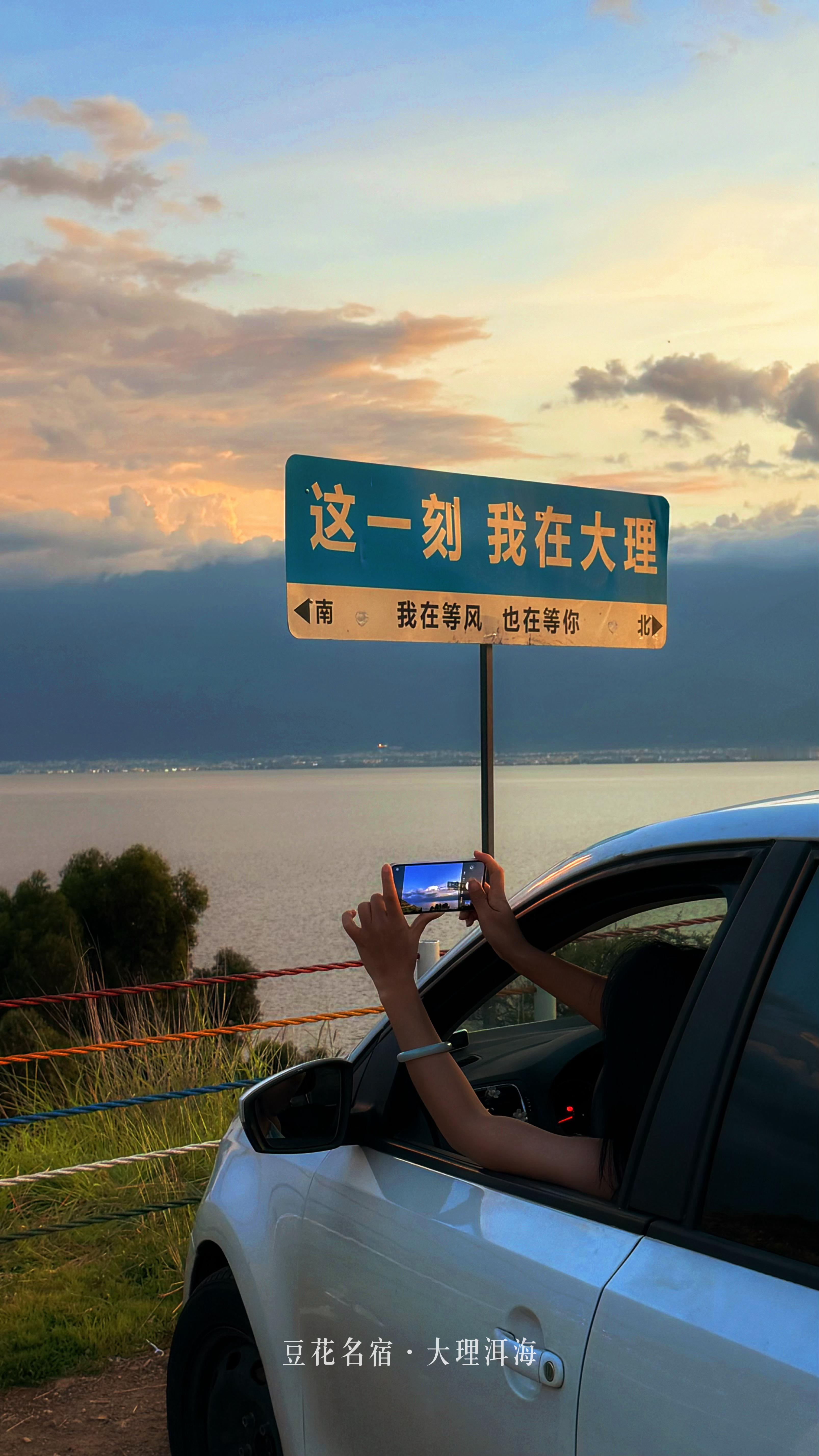大理豆花名宿海景客栈的灯火刚漫过窗台，鹿卧山海湾公路已被晚霞描上金边，车轮碾过晚