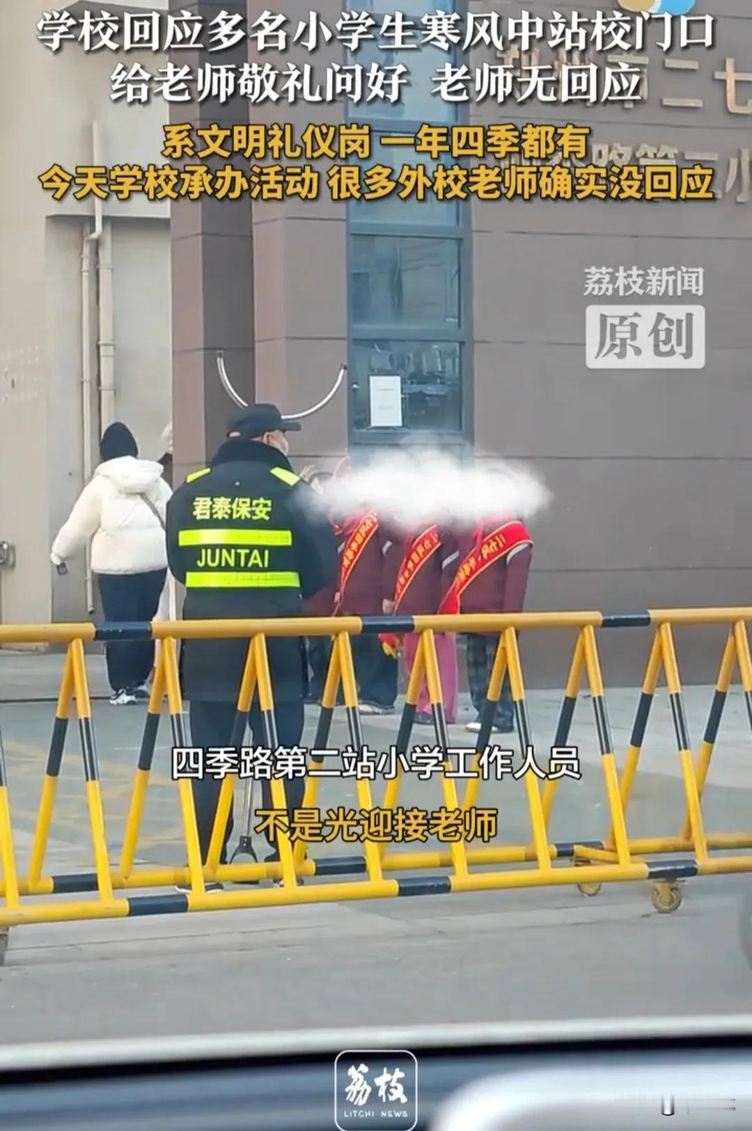 小学生身披绶带，冒着凛冽的寒风，站在学校大门前，向走进学校的老师敬礼，并齐声高喊