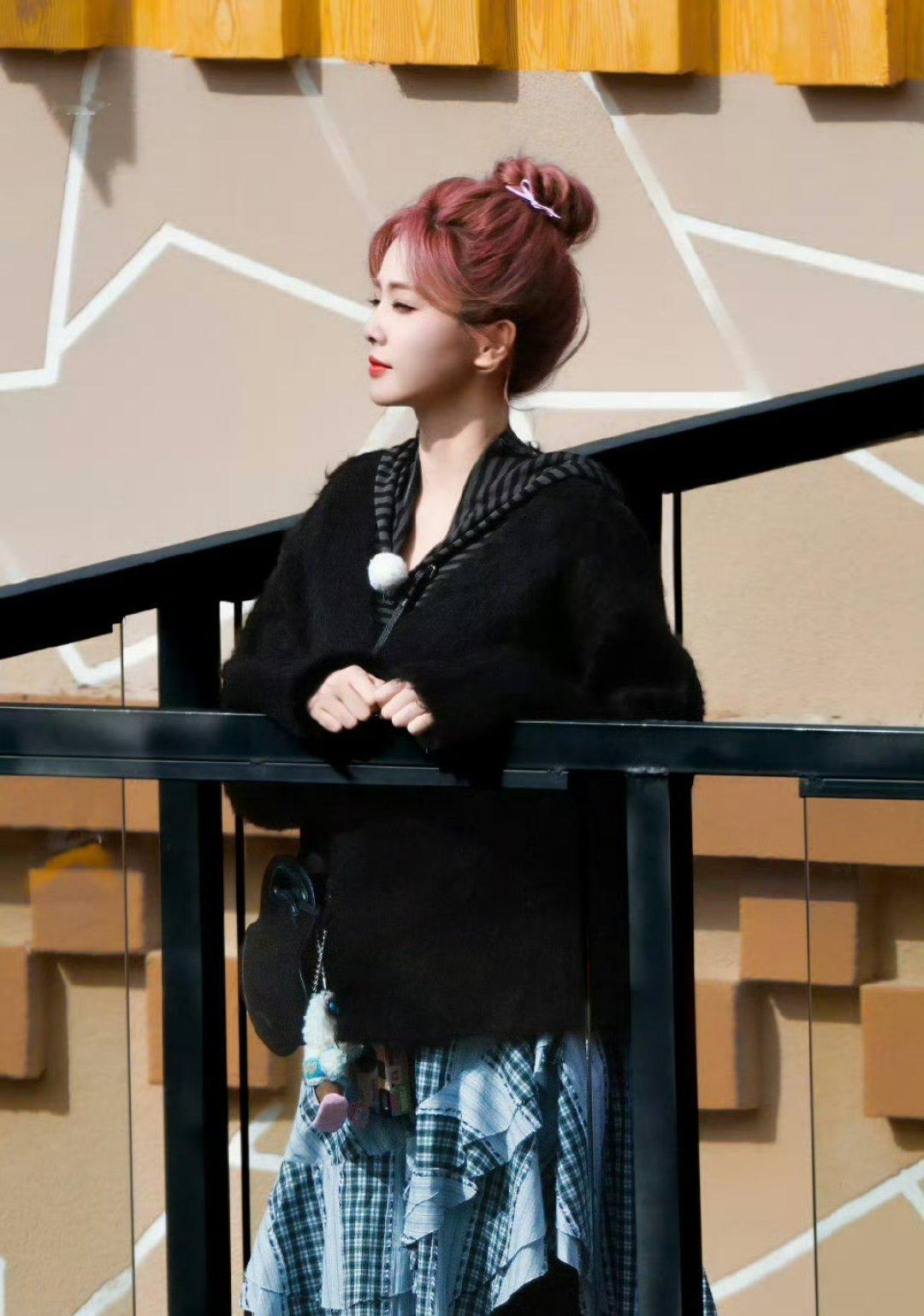 白鹿粉丸子头蓬松丸子头与雪山经幡相映成趣。这一打破常规的发色选择，不仅展现文艺工