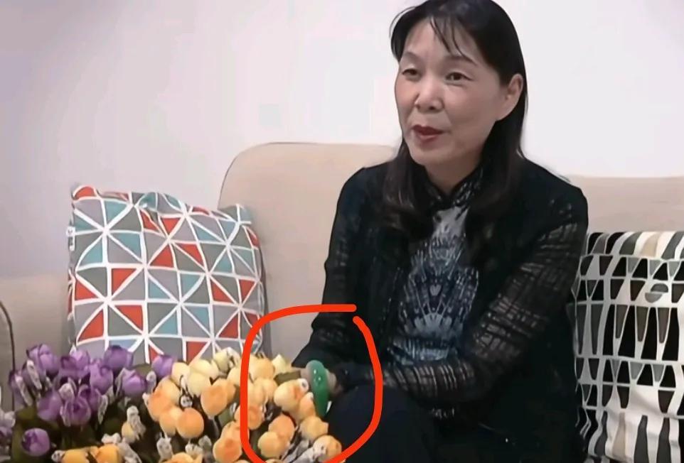 虽然有花挡着，但仍然能看见杜建英手腕处亮出的翡翠大宽胎，发蓝绿，有色有种水头，是