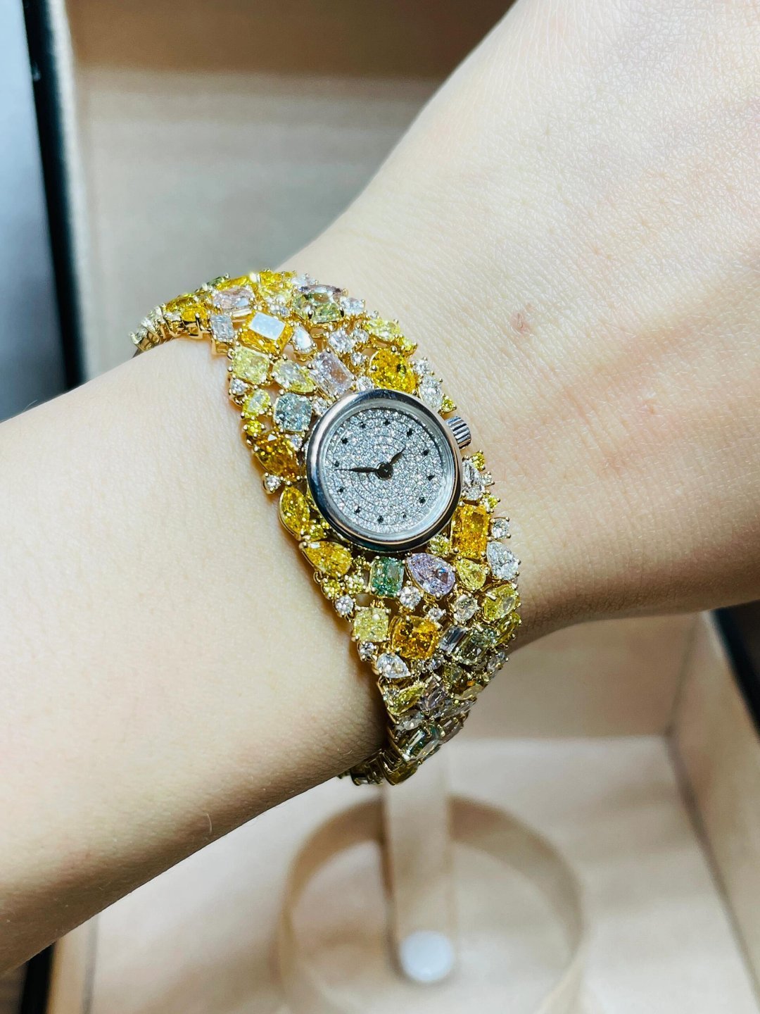 这枚天然彩钻腕表，堪称腕间的“宝石星河”——表链以黄金为底，铺镶满各色天然彩钻，