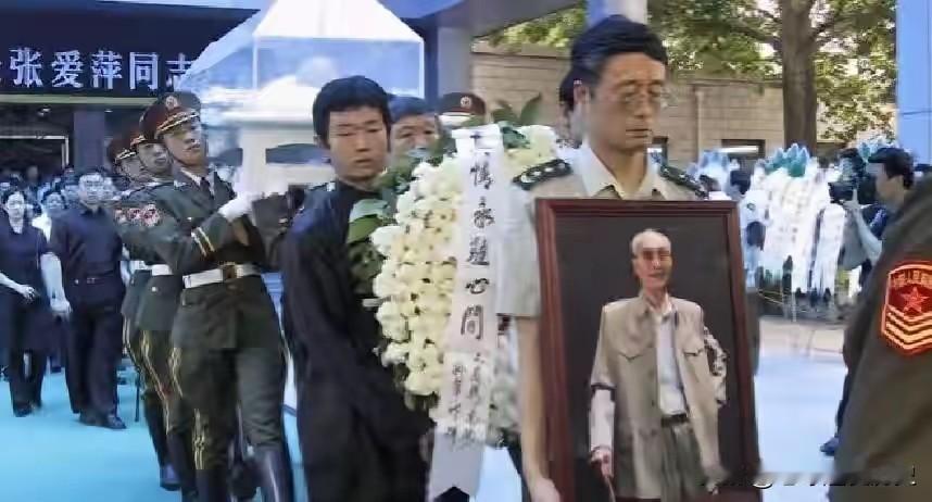 这是2003年7月张爱萍上将追悼会的送别场景。礼兵抬着灵柩缓缓前行，长子张翔手