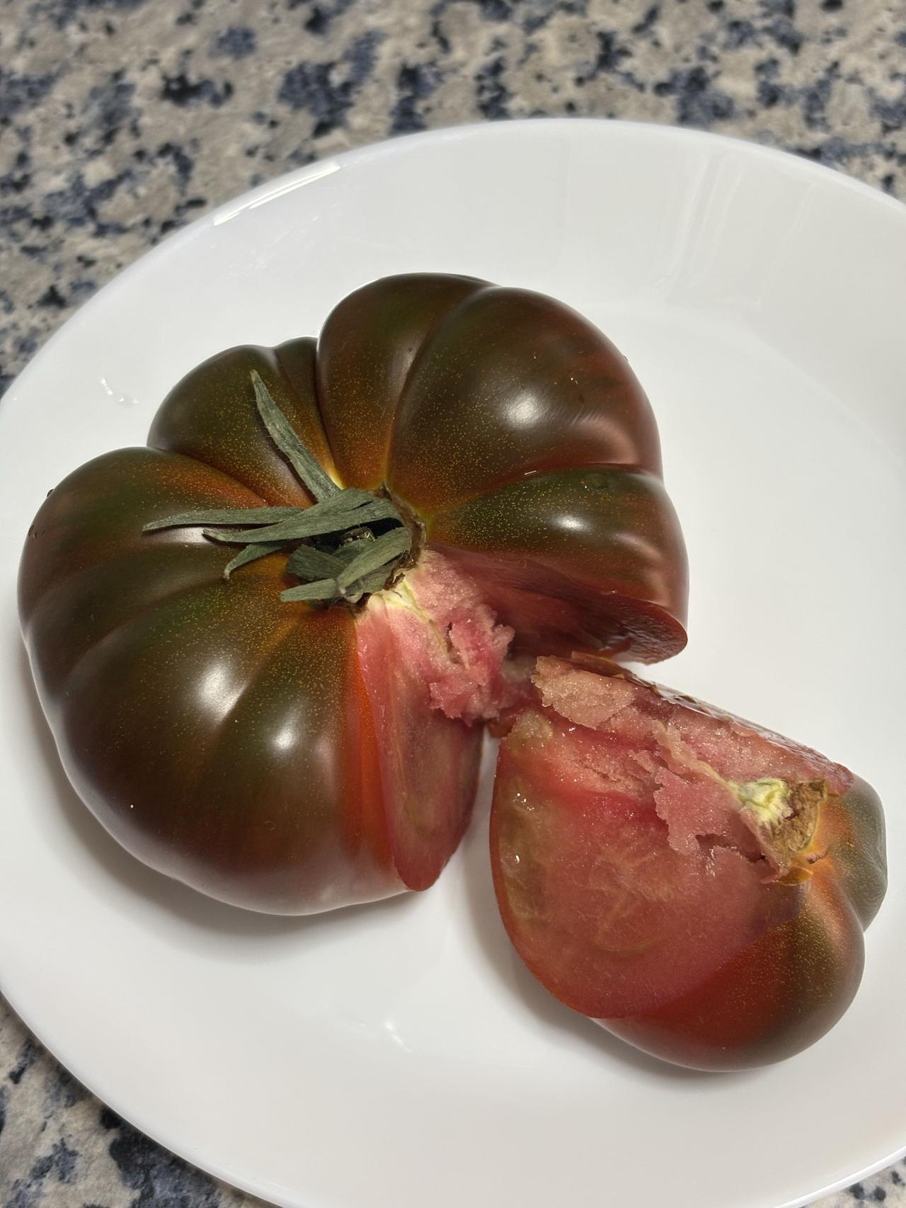 虽然丑，没想到这么好吃！这是一颗云南老味道浓汤番茄（黑色果），属于老品种番茄