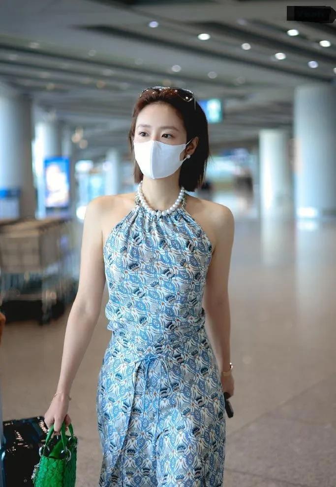 🔥高叶这机场穿搭直接把“夏日风情”焊在身上了！挂脖碎花裙衬得肩颈线条绝了，珍珠