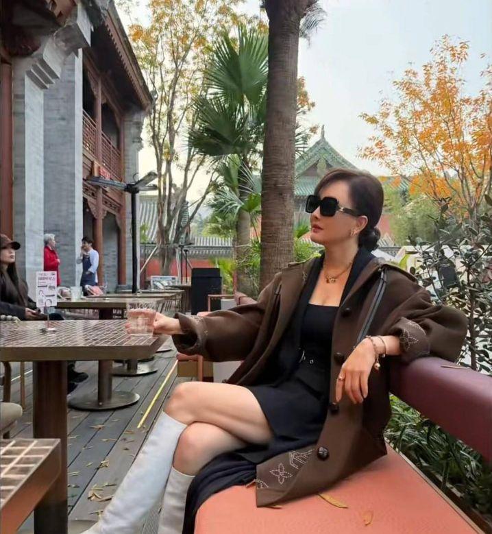 很难相信这已经是53岁的状态，整个人散发的气场太抓人眼球。牛莉闲坐户外，一